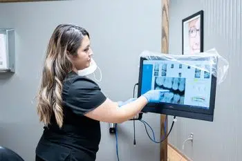Dental team member reviewing patient imaging at Happy Tooth